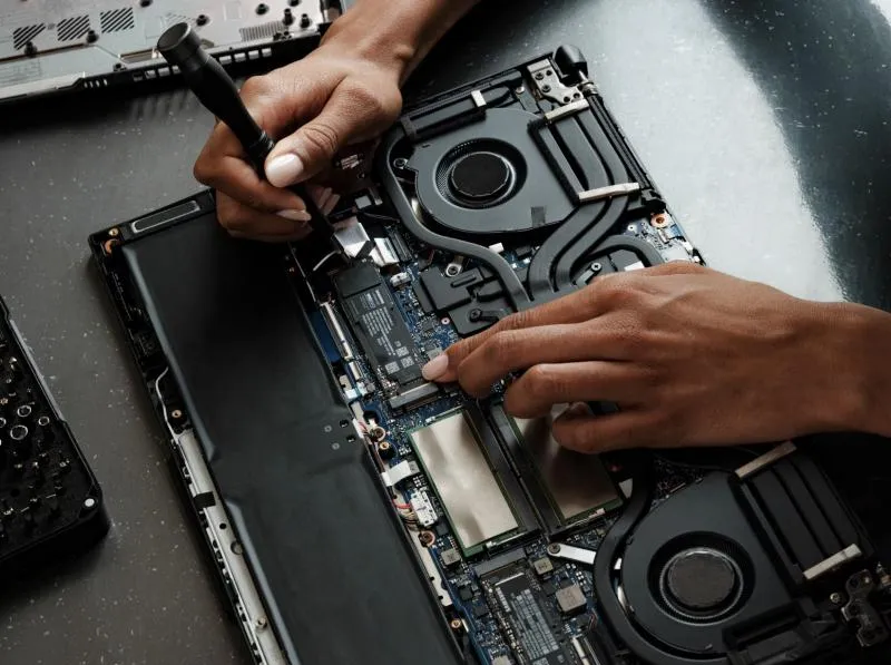 Tecnico che sostituisce componenti in un notebook aperto